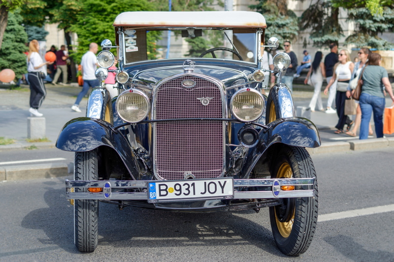 5 - Vintage Ford Model A, likely a 1928-1931 model based on its design, features a prominent chrome grille and side-mounted spare tires